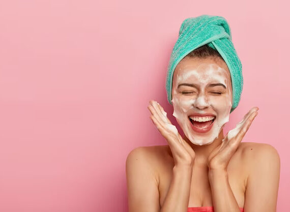 a woman is having fun double cleansing her face