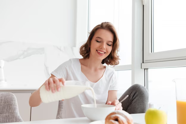 a woman pouring low fat milk on a glass